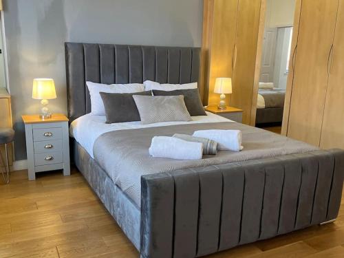 a bedroom with a large bed with two towels on it at Duplex Apartment in Greater Manchester in Oldham