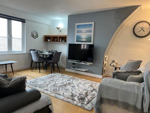 Duplex Apartment in Greater Manchester في أولدهام: غرفة معيشة مع أريكة وتلفزيون وطاولة