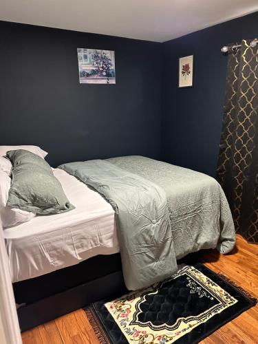 uma pequena cama num quarto com paredes azuis em Fidelia Room B Queen Bed Near EWR Airport and Penn Station em Irvington