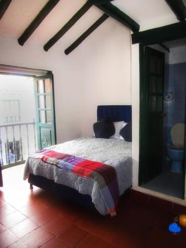 um quarto com uma cama num quarto com uma janela em Carazo chef Host & Food em Villa de Leyva