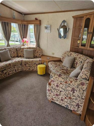 a living room with two couches and a table at PB6 in Bettws-Evan