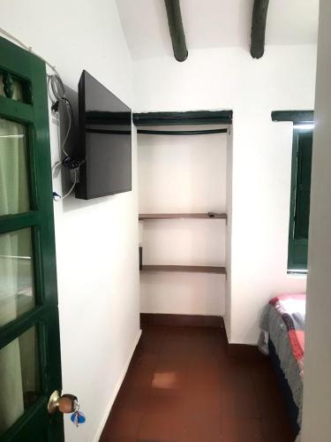 um quarto com um armário com uma porta e uma cama em Carazo chef Host & Food em Villa de Leyva