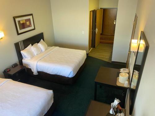 a hotel room with two beds and a table at FairBridge Inn Express Tukwila in Tukwila