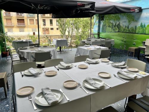 a table with white plates and utensils on it at Pensión Casa Carmen in Estella