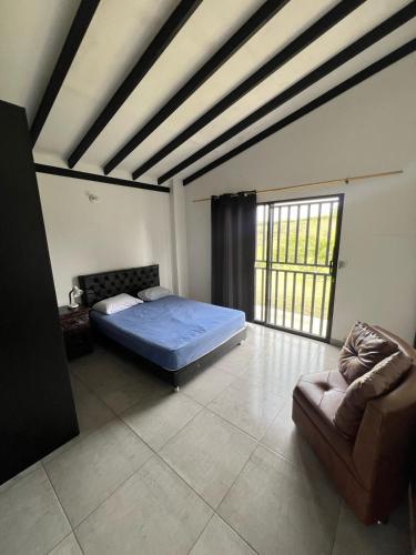 a bedroom with a bed and a couch in it at Finca Oriente Antioqueño -A 40 minutos de Medellín in San Vicente