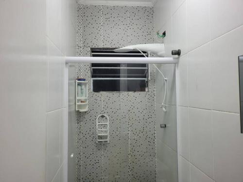 y baño con ducha y azulejos blancos y negros. en Sobrado de condominio Praia Grande VilaTupi com 2 dormitorio, en Praia Grande
