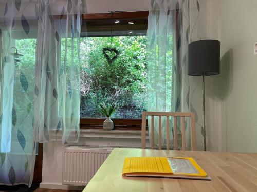 a dining room table with a window with a heart on a bush at Ferienwohnung Sonneck in Altenahr