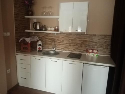 eine Küche mit weißen Schränken und einem Waschbecken in der Unterkunft Villa sv.Petka-Ohrid in Ohrid