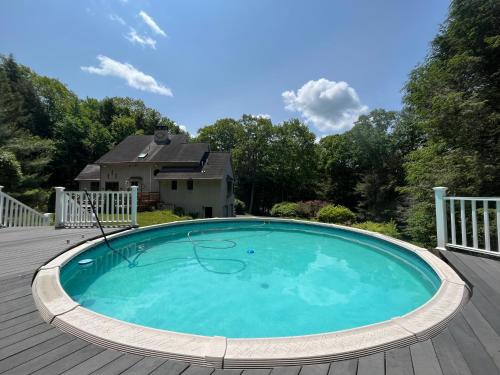 a swimming pool on a deck with a house at Sunny Peace in Harwinton