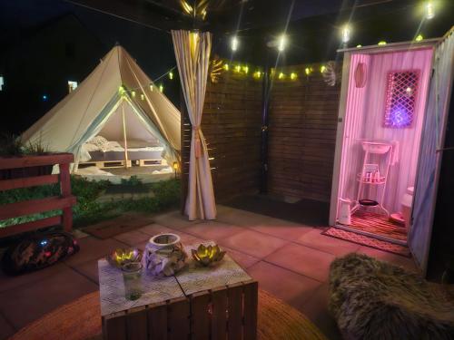 a tent with a table and a room with a bed at Punt-A-Pacha Glamping mit eigenem Garten in Kolonie Zern