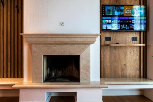 a fireplace with a tv on top of it at Hotel Arya by Mauro in Sirmione