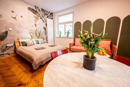 Un dormitorio con una cama y una mesa con una planta. en Trip Apartments en Cracovia