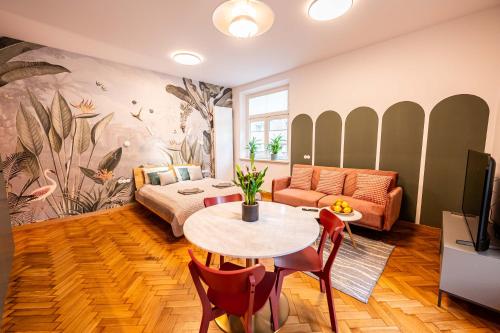 una sala de estar con una mesa y un sofá en Trip Apartments, en Cracovia
