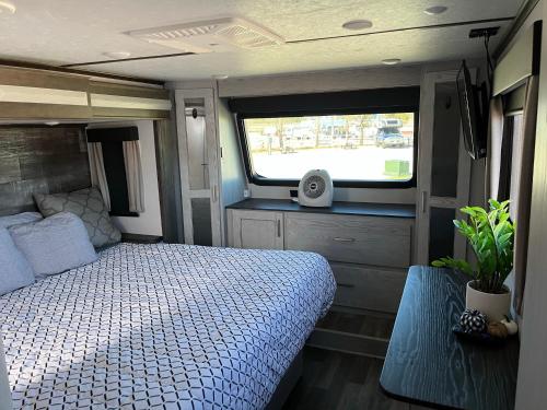 a bedroom with a bed and a window in an rv at Unique 2 Bedroom Campsite on the backside of Zion in Apple Valley