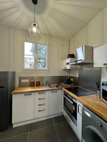 - une cuisine avec des placards blancs et un évier dans l'établissement Constantine Suits 21 - Appartement 4 personnes Dijon centre, à Dijon