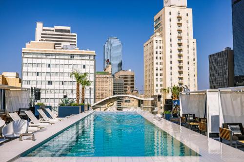 a pool on the roof of a building with chairs and buildings at Sonder at Commerce in Dallas