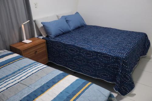 1 dormitorio con 2 camas con sábanas azules y mesita de noche en Studio Casa Amarela - a 400m do Corredor Cultural, en Mossoró