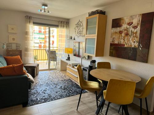 a living room with a table and chairs and a couch at Cozy apartment near Los Boliches Beach in Fuengirola