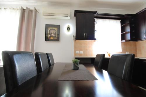 クサミルにあるOmnia Apartmentsのダイニングルーム(テーブル、黒い椅子付)