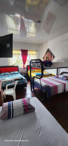 a room with three bunk beds in a room at Hotel Arte Santa Rosa in Santa Rosa de Cabal
