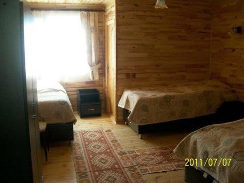 1 dormitorio con 2 camas en una cabaña de madera en Dedaena Pansiyon, en Artvin