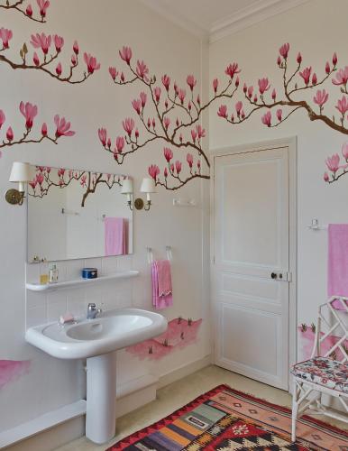 a bathroom with a sink and pink flowers on the wall at Domaine Maze Churchill in Burie