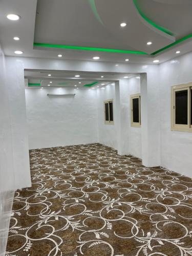 منتزه السوده السياحي في Muqammar: غرفة كبيرة مع أرضية مفروشة بالسجاد وجدران بيضاء