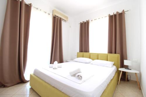 a bedroom with a large bed in front of windows at Omnia Apartments in Ksamil