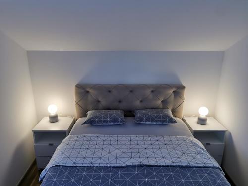 Lada في Pasuljište: غرفة نوم بسرير ازرق مع مواقف ليلتين
