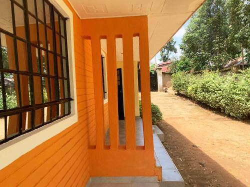 una puerta naranja en el lateral de un edificio en Summer Homes Bungoma, en Bungoma