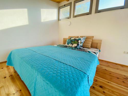 a large blue bed in a room with windows at Dolly - Waterfront Villa no 154L in Ulcinj