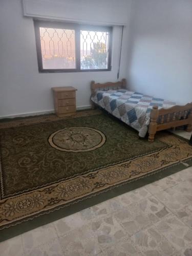a bedroom with a bed and a window and a rug at شقق ايلين 