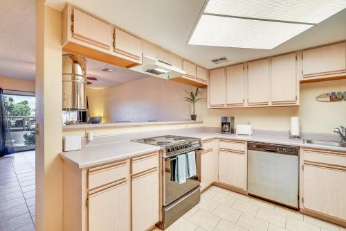 a kitchen with wooden cabinets and a stove top oven at Walk to Golf and Beach Queens Bay Resort Condo in Lake Havasu City