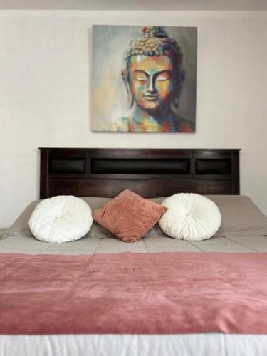 a bed with two pillows and a painting on the wall at Casa Di Patti B & B in Santiago