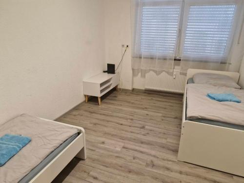 - une chambre avec 2 lits et un bureau dans l'établissement L8 Street - Mühlacker, à Mühlacker