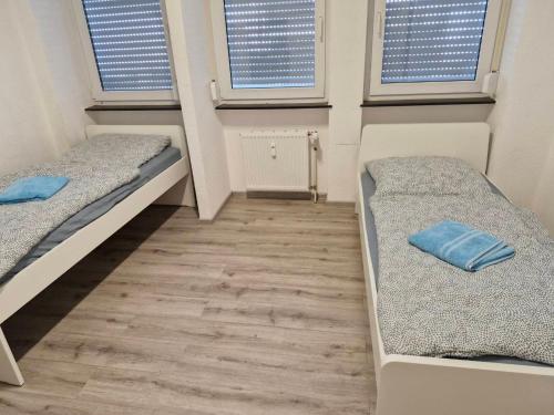 two beds in a small room with two windows at L8 Street - Mühlacker in Mühlacker