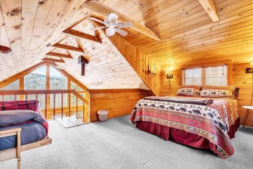 a log cabin bedroom with two beds and a ceiling fan at Gorgeous Chalet! VIEWS! Hot Tub! Sleeps 12! Games in Bethel