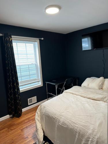 a bedroom with a bed and a blue wall at Fidelia Crystal Room, Queen Bed minutes from Newark Liberty International Airport and Newark Penn Station in Irvington