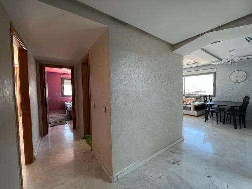 an empty room with a table and a dining room at Tanger centre-ville - Appartement luxueux avec vue mer et piscine in Tangier