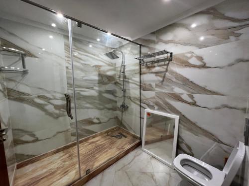 a bathroom with a shower and a toilet at Tanger centre-ville - Appartement luxueux avec vue mer et piscine in Tangier
