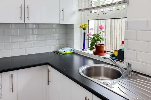 a kitchen counter with a sink and a window at Hampton Court Cottage in Hampton