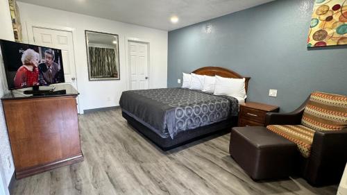 Piccola camera d'albergo con letto e sedia di Hitching Post Studios Inn a Santa Cruz