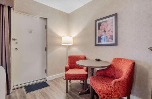 a room with two chairs and a table and a lamp at Best Western Plus Cairn Croft Hotel in Niagara Falls