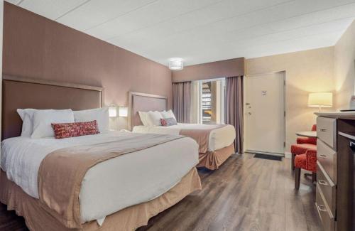 a hotel room with two beds and a television at Best Western Plus Cairn Croft Hotel in Niagara Falls