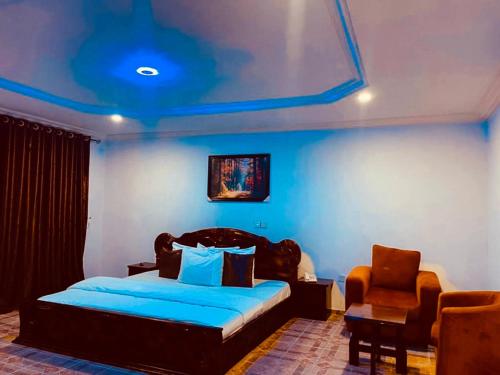 a bedroom with a bed with a blue ceiling at Executive Gold Hotel in Abuja