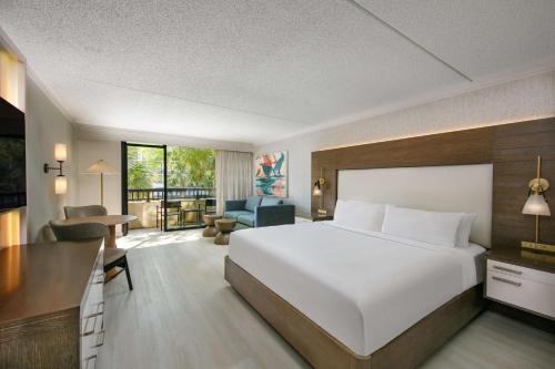 a bedroom with a large white bed and a living room at Sonesta Resort Hilton Head Island in Hilton Head Island