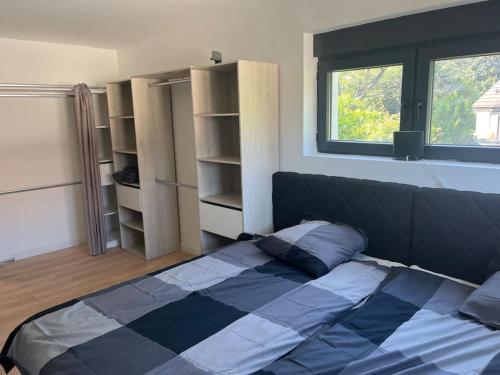 - une chambre avec un lit, une fenêtre et des étagères dans l'établissement Maison paisible cadre agréable avec spa privatisé, à Lutterbach