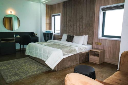 een slaapkamer met een bed, een bureau en een stoel bij New View Beach Hotel and Resort Lekki Lagos in Lagos