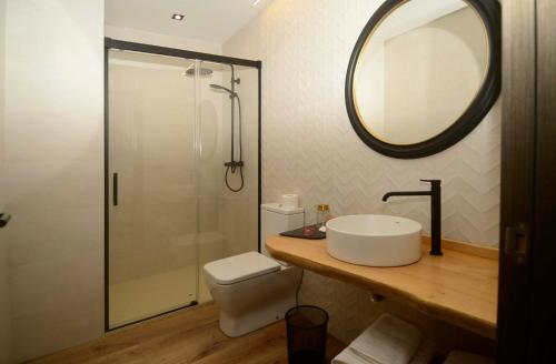 A Reigada Hotel Restaurante في غرانداس دي ساليمي: حمام مع حوض ودش مع مرآة