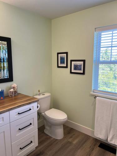 a white bathroom with a toilet and a window at Wellington House in Nanaimo